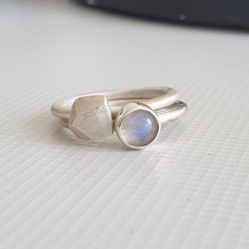 Two silver rings on a textured white surface