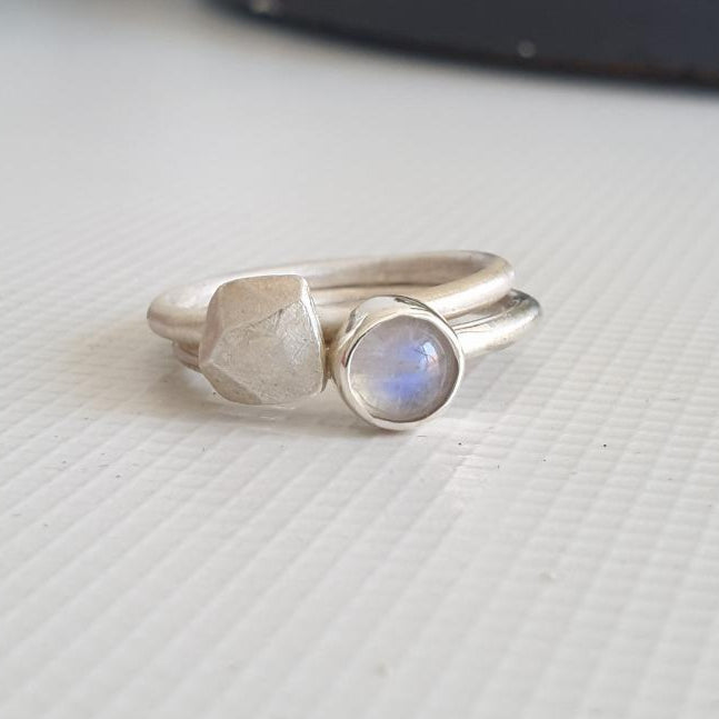 Two silver rings on a textured white surface