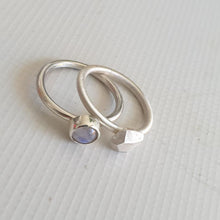 Carica l&#39;immagine nel visualizzatore di Gallery, Two silver rings with gemstones on a light gray background