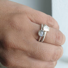 Carica l&#39;immagine nel visualizzatore di Gallery, Close-up of a hand wearing two silver rings with gemstones on a neutral background